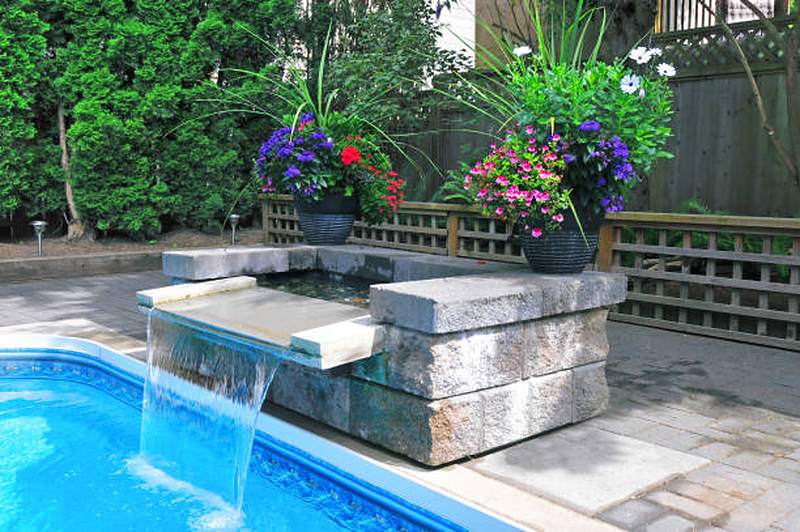 Pool waterfall built into a stone block wall with flower planters, Irene